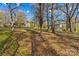 A single-story home with wood siding and a partial basement, set on a leafy lot with mature trees at 216 E Georgia Ave, Bessemer City, NC 28016
