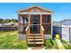View of a backyard with a screened-in porch, wooden steps, and adjacent lawn at 2425 Barkers Ridge Dr, Bessemer City, NC 28016