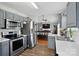 Modern kitchen featuring stainless steel appliances, gray cabinetry, and an open view to the dining area at 2425 Barkers Ridge Dr, Bessemer City, NC 28016