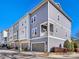 Modern townhome with attached garages boasts neutral siding, a balcony and updated windows at 266 Iverson Way, Charlotte, NC 28203