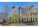 Exterior view of well-kept townhouses with inviting entrances, landscaped yards, and clear signage. 