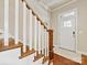 Warm foyer with hardwood steps, white railings, and a view of the front door that provides natural light at 266 Iverson Way, Charlotte, NC 28203