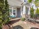 Charming front porch with a cozy blue cushioned bench and beautiful landscaping, perfect for relaxing outdoors at 266 Iverson Way, Charlotte, NC 28203