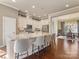 Bright kitchen features a large island with seating, pendant lighting, stainless steel appliances and an open layout to the dining room at 266 Iverson Way, Charlotte, NC 28203