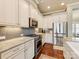 Bright kitchen with white cabinets, stainless steel appliances, granite countertops, and a gray mosaic backsplash at 266 Iverson Way, Charlotte, NC 28203