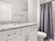 Bright bathroom featuring a granite countertop, white vanity, chrome fixtures, and a combination shower and tub at 2768 Suffolk Pl, Fort Mill, SC 29715