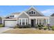 Charming two-story home featuring stone accents, a covered porch, and a well-manicured lawn at 2768 Suffolk Pl, Fort Mill, SC 29715