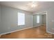 A simple bedroom featuring hardwood floors, neutral paint, closet door, and natural light at 300 Bell St # 80, Mount Holly, NC 28120