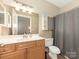 Bathroom with white sink, wood cabinets, and a shower curtain at 301 E Tremont Ave, Charlotte, NC 28203
