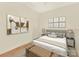 Bedroom with decorative wall art, a neutral color scheme, and a wooden trunk at the foot of the bed at 301 E Tremont Ave, Charlotte, NC 28203
