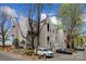 Multi-story building with gray siding, manicured landscaping, and multiple parked vehicles at 306 S Cedar St # 10, Charlotte, NC 28202