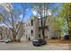 Multi-story building exterior with gray siding, black parked car and well-maintained landscaping at 306 S Cedar St # 10, Charlotte, NC 28202