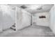Spacious finished basement area with carpeted floors, white walls, and access to stairs at 3717 Bodenham Ct, Charlotte, NC 28215