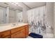 Well-maintained bathroom with wooden cabinets, a single sink and shower with printed curtain at 3717 Bodenham Ct, Charlotte, NC 28215