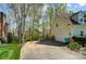 Spacious two-car garage with a long driveway, surrounded by mature trees and lush greenery at 3717 Bodenham Ct, Charlotte, NC 28215
