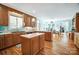 Open-concept kitchen boasts wood cabinets, hardwood floors, a center island, and a seamless transition to the dining area at 3717 Bodenham Ct, Charlotte, NC 28215