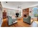Bright living room with hardwood floors, a brick fireplace, and large windows offering ample natural light at 3717 Bodenham Ct, Charlotte, NC 28215