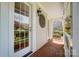 Inviting covered porch featuring brick flooring, white railings, and decorative wall art, offering a cozy outdoor space at 3717 Bodenham Ct, Charlotte, NC 28215
