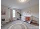 Comfortable Bedroom with a white crib, gray rocking chair, and natural decor at 3810 New Salem Rd, Monroe, NC 28110