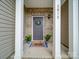 Charming front entry with a brick facade, welcoming wreath, and potted plants at 3810 New Salem Rd, Monroe, NC 28110