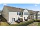 View of a two-story house with an outdoor patio and balcony, surrounded by lush landscaping, creating a private oasis at 39617 Rosebay Ct, Fort Mill, SC 29707