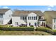 Rear view of a two-story house featuring an outdoor patio and balcony, complemented by well-manicured greenery at 39617 Rosebay Ct, Fort Mill, SC 29707