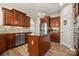 This kitchen features wood cabinets, stainless appliances, granite counters, a central island, and wood flooring at 39617 Rosebay Ct, Fort Mill, SC 29707