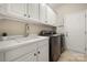 Bright laundry room features a sink, washer and dryer, white cabinets and a door to the exterior at 39617 Rosebay Ct, Fort Mill, SC 29707