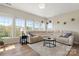 Comfortable living room featuring a sectional sofa, large windows, and hardwood flooring at 39617 Rosebay Ct, Fort Mill, SC 29707