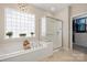 Bright bathroom featuring a soaking tub next to a window and a separate glass enclosed shower at 39617 Rosebay Ct, Fort Mill, SC 29707