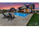 Charming backyard with a beautiful pool, patio, and outdoor kitchen, perfect for evening gatherings at 406 Sugar Maple Ln, Weddington, NC 28104