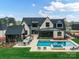 Aerial view of a large backyard with an in-ground pool, outdoor kitchen, and lush green lawn at 406 Sugar Maple Ln, Weddington, NC 28104