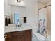 Traditional bathroom showcases a wood vanity with a marble countertop and a shower-tub combo with a floral shower curtain at 406 Sugar Maple Ln, Weddington, NC 28104