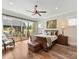 A primary bedroom suite features a king bed, wooden floors, a ceiling fan and backyard access at 406 Sugar Maple Ln, Weddington, NC 28104