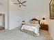 Spacious bedroom features neutral walls, carpet, ceiling fan, and traditional-style bed with carved headboard and matching side table at 406 Sugar Maple Ln, Weddington, NC 28104