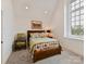 Cozy bedroom with soft carpet, wooden bed frame, and lots of natural light from a large window; decorated with colorful accents at 406 Sugar Maple Ln, Weddington, NC 28104