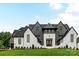 Stunning new construction features a stylish white brick and gray exterior with a beautifully manicured lawn at 406 Sugar Maple Ln, Weddington, NC 28104