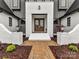 Inviting front entrance featuring double doors, brick walkway, decorative lanterns, and well-maintained landscaping at 406 Sugar Maple Ln, Weddington, NC 28104