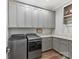 The laundry room features gray cabinetry, granite countertop and stainless front load appliances at 406 Sugar Maple Ln, Weddington, NC 28104