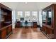 Spacious home office with hardwood floors, large windows, and built-in shelving that create a functional and stylish workspace at 406 Sugar Maple Ln, Weddington, NC 28104