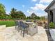 Outdoor bar area with stone facade, seating, a grill, and a beautifully landscaped backyard at 406 Sugar Maple Ln, Weddington, NC 28104