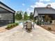 Charming outdoor dining area with a stone patio, outdoor fireplace, and lush greenery, perfect for entertaining at 406 Sugar Maple Ln, Weddington, NC 28104