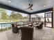 Covered patio with ceiling fan, stone flooring, and comfortable seating overlooking the pool and backyard at 406 Sugar Maple Ln, Weddington, NC 28104