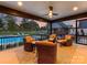 Covered patio with ceiling fan, stone flooring, and comfortable seating overlooking the pool at sunset at 406 Sugar Maple Ln, Weddington, NC 28104