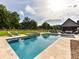 Beautiful backyard pool and spa area with stone accents, surrounded by lush greenery and outdoor seating at 406 Sugar Maple Ln, Weddington, NC 28104