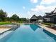 Luxurious backyard pool and spa, surrounded by manicured lawn, lounge chairs, and an outdoor dining area at 406 Sugar Maple Ln, Weddington, NC 28104
