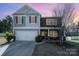 Charming two-story home featuring a stone facade, gray siding, and a well-maintained front yard at 428 Wheat Field Dr, Mount Holly, NC 28120