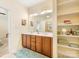 Well-lit bathroom boasts double sinks, wooden cabinetry, and convenient built-in shelving at 4434 Patriots Hill Rd, Mint Hill, NC 28227