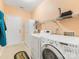 Functional laundry room equipped with white washer, dryer, shelving and storage space at 4434 Patriots Hill Rd, Mint Hill, NC 28227