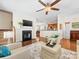 Cozy living room with fireplace, large tv, hardwood floors, and view to kitchen at 4434 Patriots Hill Rd, Mint Hill, NC 28227
